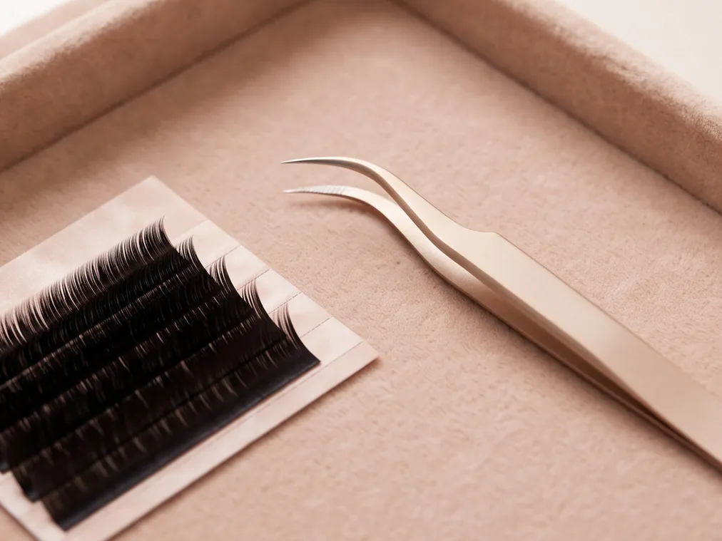 Pinzas y una plancha de extensiones de pestañas
